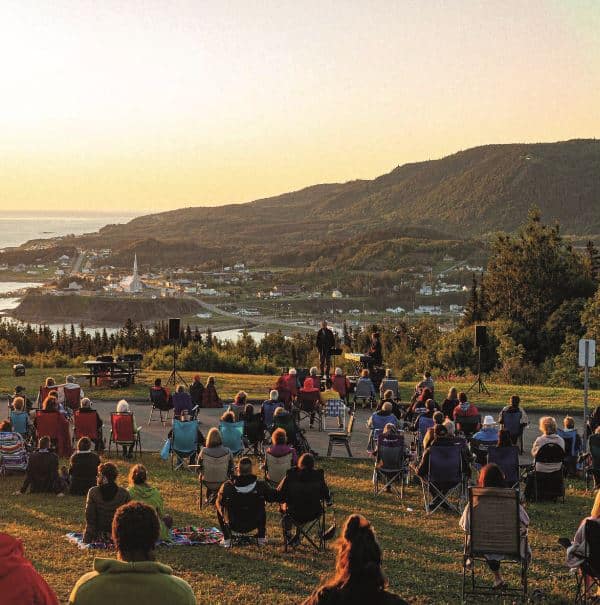 © A. Cotton : sur la grande vallée le public assis sur ses chaises est admiratif du concert en pleine nature
