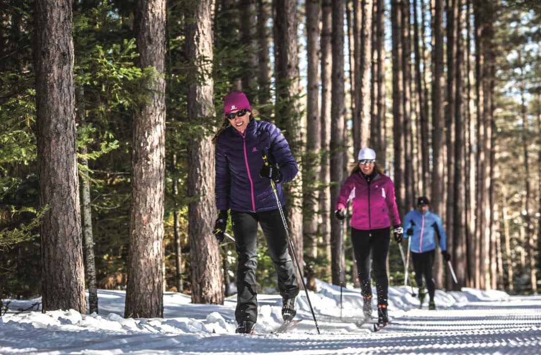 © D-tour Tremblant : Trois randonneurs en chaussures de ski de fond au milieu de la forêt