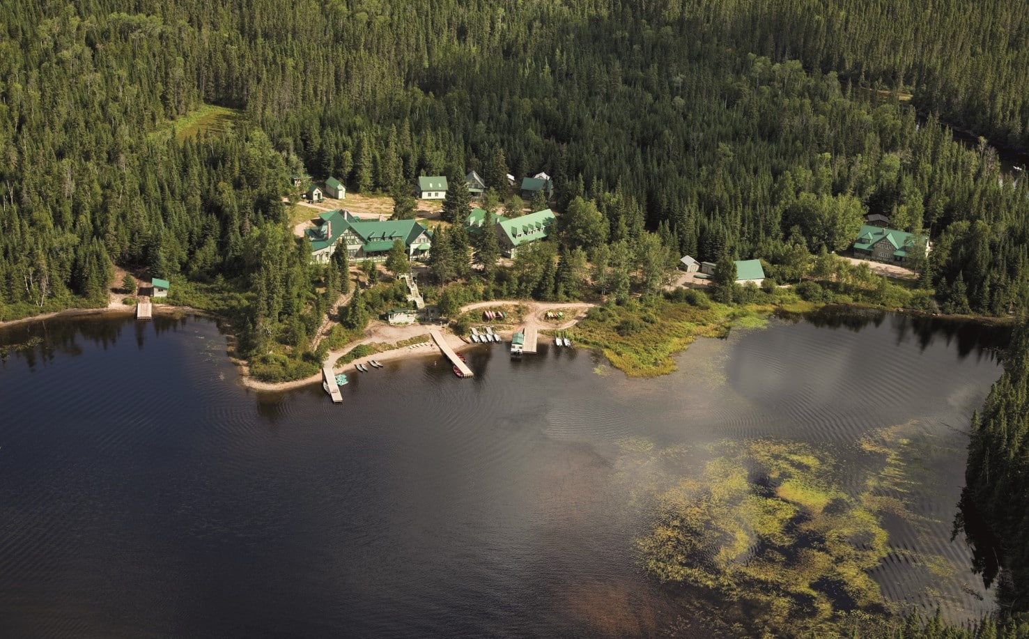 © Pourvoirie du Triton : vue aérienne sur l'auberge Le Batiscan, au milieu de la forêt