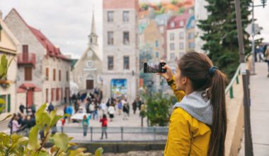 Wi-fi et connexion mobile au Québec - Jeune fille prenant une photo dans le Vieux Québec avec son téléphone portable - Conseil wi-fi / téléphone au Québec