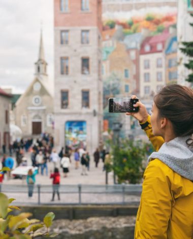 Wi-fi et connexion mobile au Québec - Jeune fille prenant une photo dans le Vieux Québec avec son téléphone portable - Conseil wi-fi / téléphone au Québec